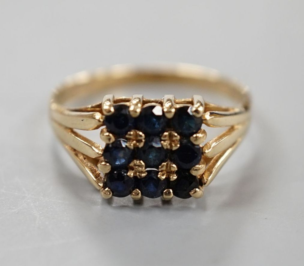 A modern 9ct gold and nine stone sapphire set tablet ring, size R/S, gross weight 2.7 grams.